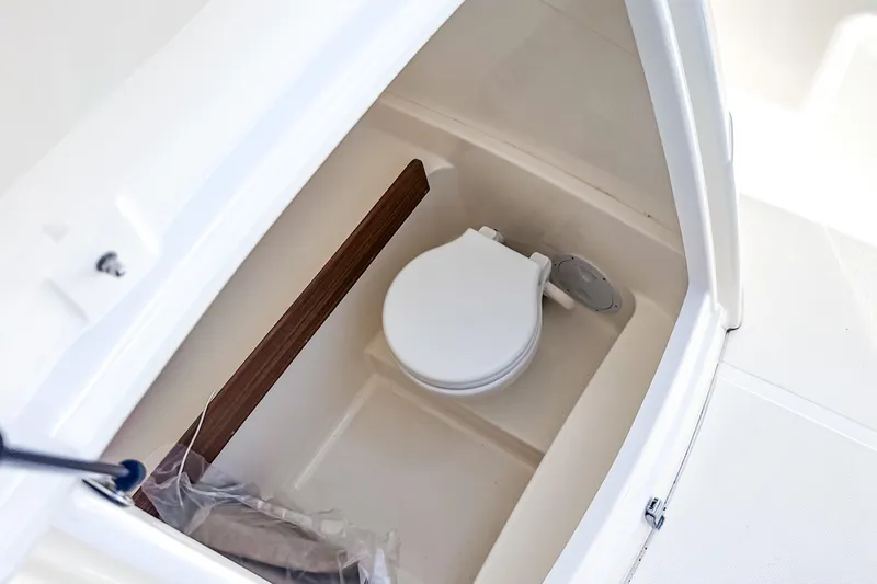 Slide: The Image of 2023 White Shark 230CC boat interior with compact marine toilet. - 8