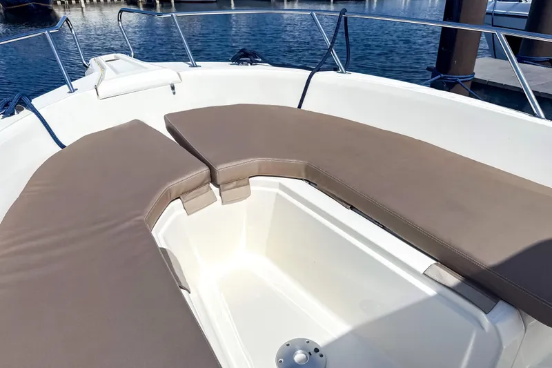Slide: The Image of 2023 White Shark 230CC boat with cushioned seating, docked by the water. - 3
