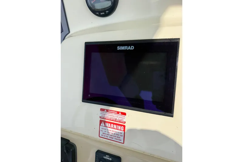 Slide: The Image of Simrad display on 2017 Scout 215 XSF boat dashboard with warning labels. - 11