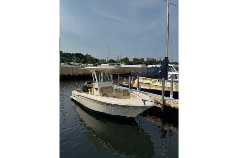 The Image of 2017 Scout 215 XSF boat docked in a marina under clear skies. - 0
