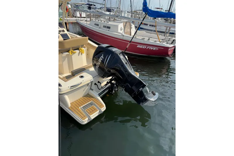 Slide: The Image of 2017 Scout 215 XSF boat with Mercury outboard motor docked at marina. - 3