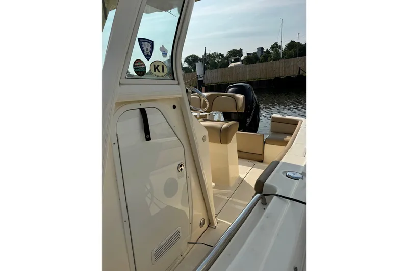 Slide: The Image of 2017 Scout 215 XSF boat interior with steering wheel and seating, docked by the water. - 9