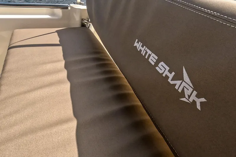 Slide: The Image of 2023 White Shark 210CC boat seat with logo, sunlight casting shadows. - 8