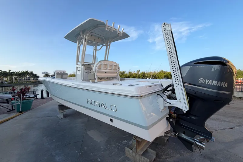 Slide: The Image of 2018 Robalo 246 Cayman boat with Yamaha engine docked by the water. - 2