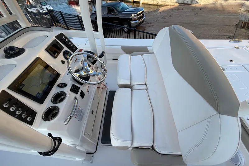 Slide: The Image of 2018 Robalo 246 Cayman boat cockpit with steering wheel and navigation display. - 9