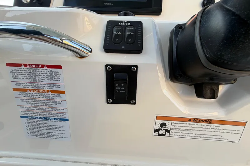 Slide: The Image of 2018 Robalo 246 Cayman boat dashboard with warning labels and controls. - 31