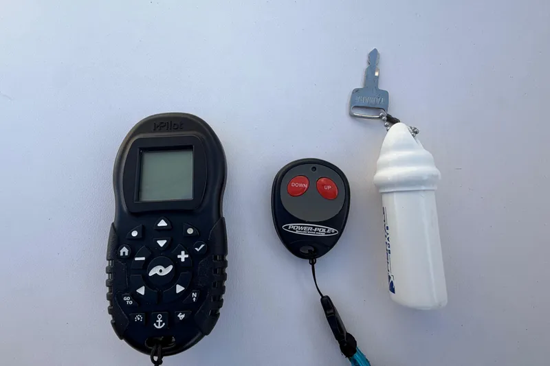 Slide: The Image of Remote controls and key for 2018 Robalo 246 Cayman boat on white surface. - 35