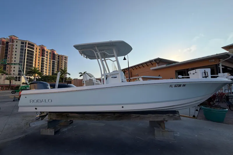 Slide: The Image of 2018 Robalo 246 Cayman boat on display, with buildings in the background. - 3