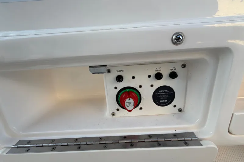 Slide: The Image of Control panel on a 2018 Robalo 246 Cayman boat, featuring switches and a voltage relay. - 34