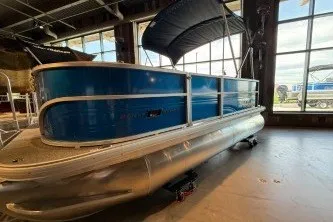 The Image of 2026 Sun Tracker Party Barge 16 DLX pontoon boat in showroom with canopy. - 0