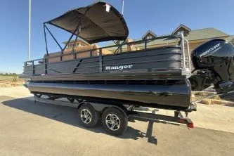 The Image of 2026 Ranger 220F pontoon boat with canopy on a trailer, parked outdoors. - 0