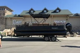 Slide: The Image of 2026 Ranger 220F boat on trailer in front of dealership building. - 68