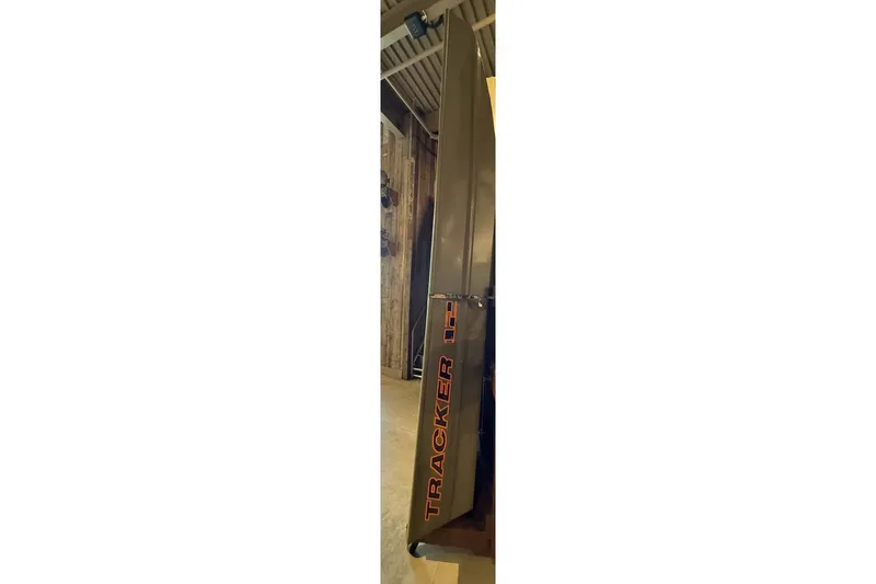 The Image of 2026 Tracker Grizzly 12 Jon boat displayed vertically in a wooden interior setting. - 0
