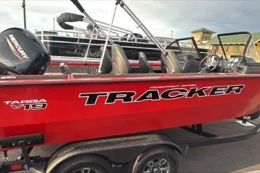 The Image of 2026 Tracker Targa V-19 Combo boat in vibrant red, parked on a trailer. - 0