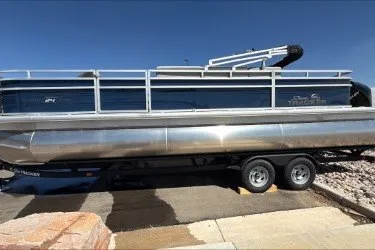The Image of 2026 Sun Tracker Sportfish 24 XP3 pontoon boat on trailer, side view. - 0