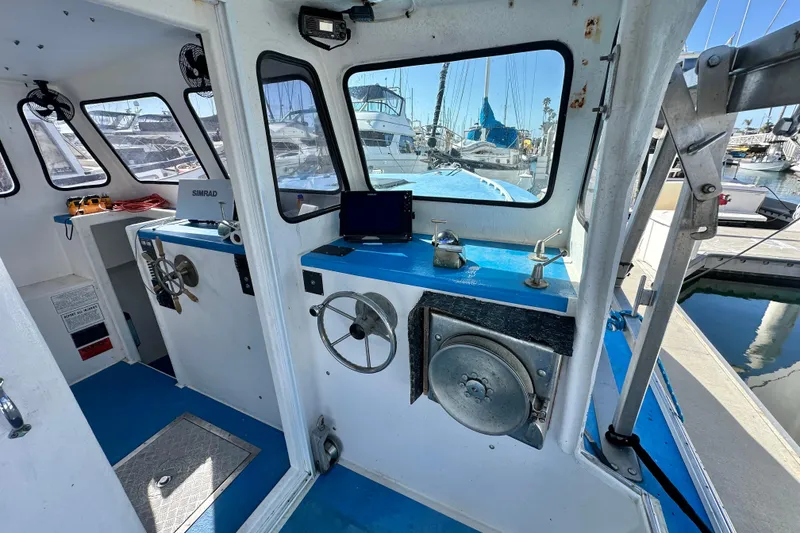 Slide: The Image of Interior of a 2016 Libby Downeast boat with steering wheels and navigation equipment. - 16