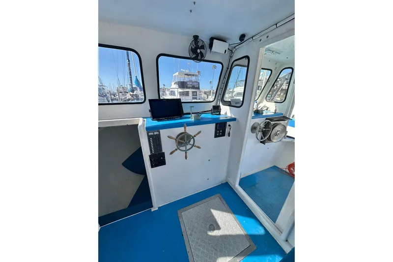 Slide: The Image of Interior of 2016 Libby Downeast boat with steering wheel and navigation equipment. - 17