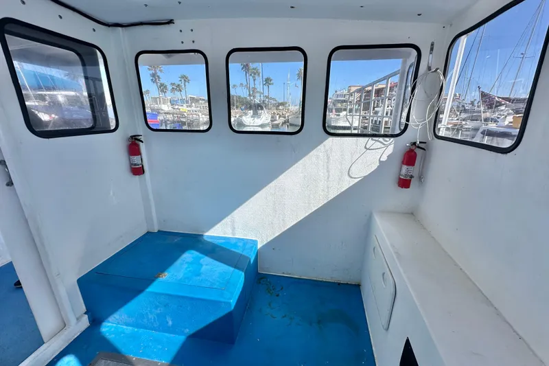 Slide: The Image of Interior of 2016 Libby Downeast boat with blue flooring and multiple windows. - 19