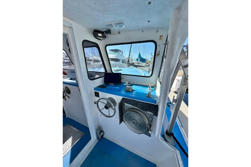 Slide: The Image of Interior of a 2016 Libby Downeast boat with steering wheel and navigation equipment. - 18