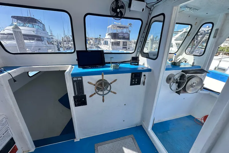 Slide: The Image of Interior of a 2016 Libby Downeast boat with steering wheel and control panel. - 15