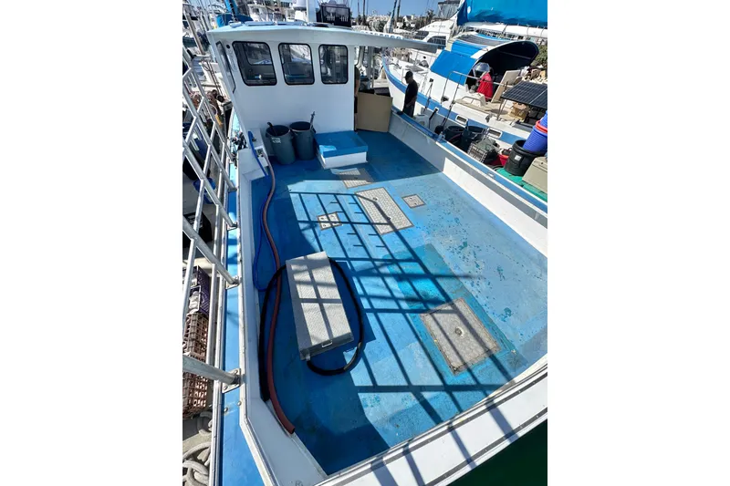 Slide: The Image of 2016 Libby Downeast boat deck with blue flooring and equipment, docked at a marina. - 27