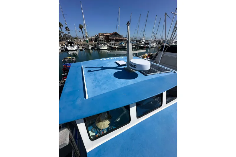Slide: The Image of Blue 2016 Libby Downeast boat docked in a marina with sailboats. - 24