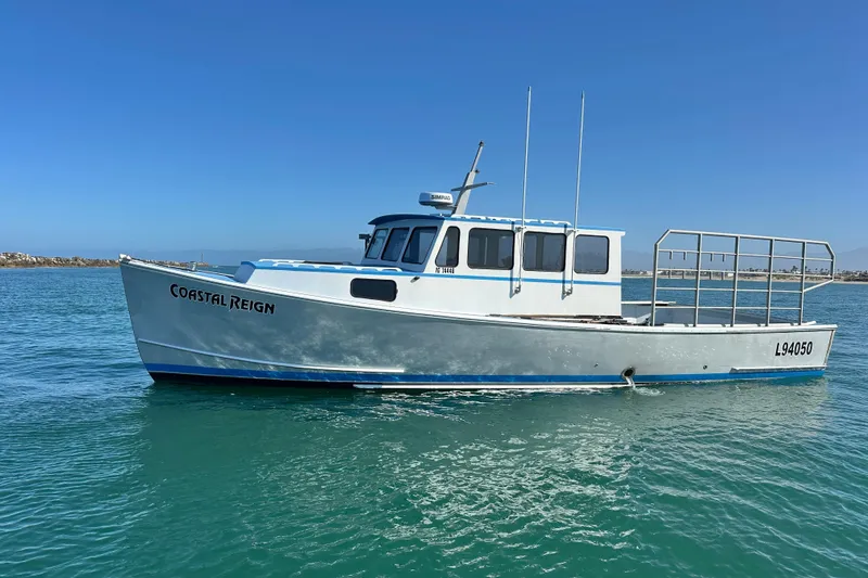 Slide: The Image of 2016 Libby Downeast boat "Coastal Reign" on calm water under clear blue sky. - 3