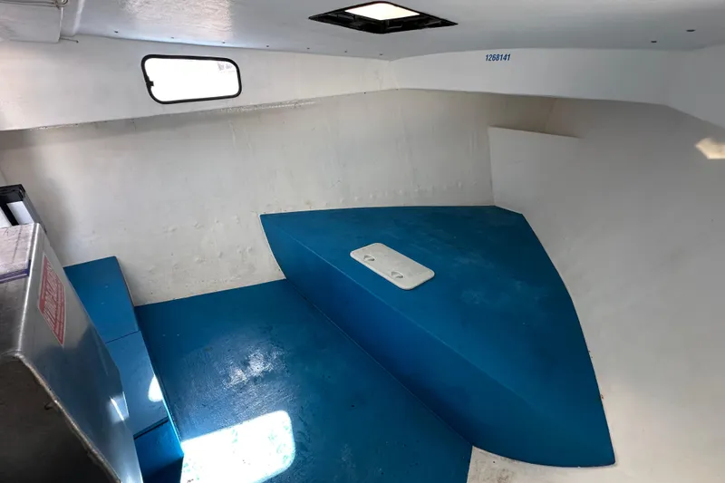 Slide: The Image of Interior of a 2016 Libby Downeast boat with blue flooring and white walls. - 21