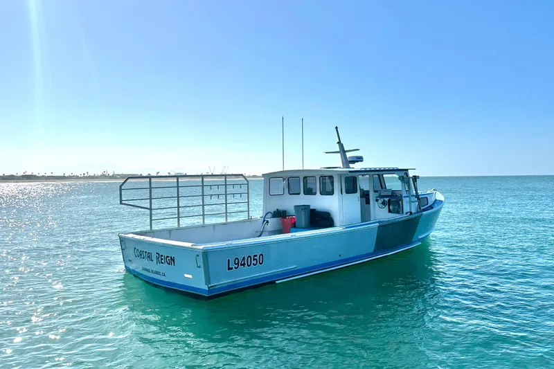 Slide: The Image of 2016 Libby Downeast boat "Coastal Reign" on calm ocean waters under clear blue sky. - 5