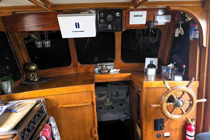 Slide: The Image of 1978 CHB 34 Trawler interior with wooden helm, navigation equipment, and cozy cabin space. - 7