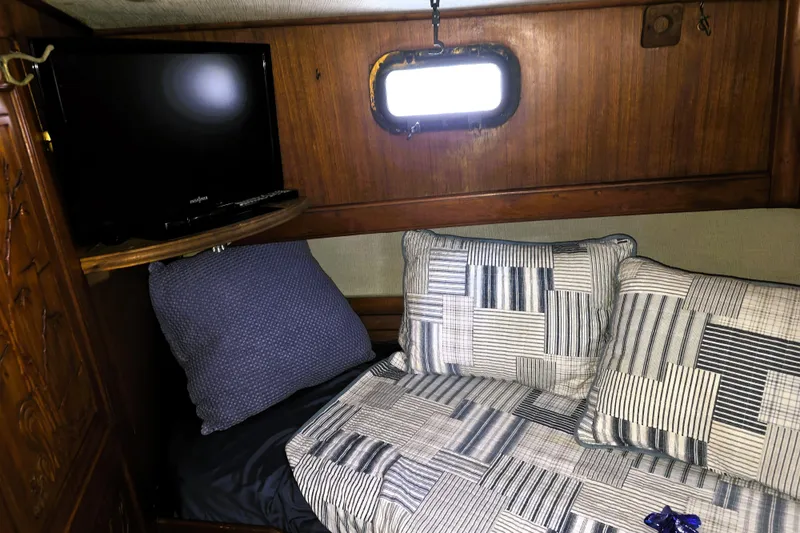 Slide: The Image of Cozy cabin interior of 1978 CHB 34 trawler with bed, pillows, and TV. - 11