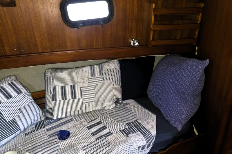 Slide: The Image of Cozy cabin interior of 1978 CHB 34 trawler with patterned bedding and wooden accents. - 12