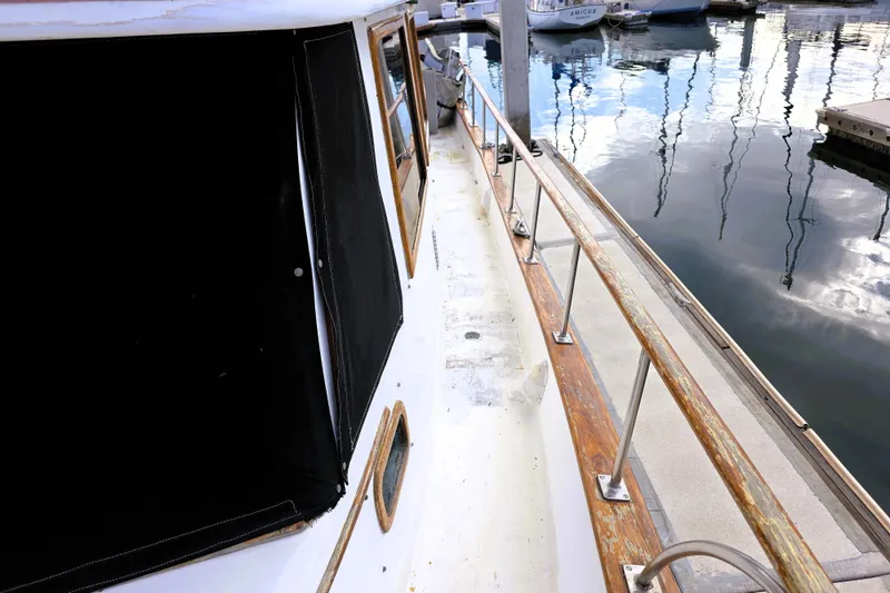 Slide: The Image of 1978 CHB 34 Trawler docked, showcasing wooden railings and cabin exterior. - 24