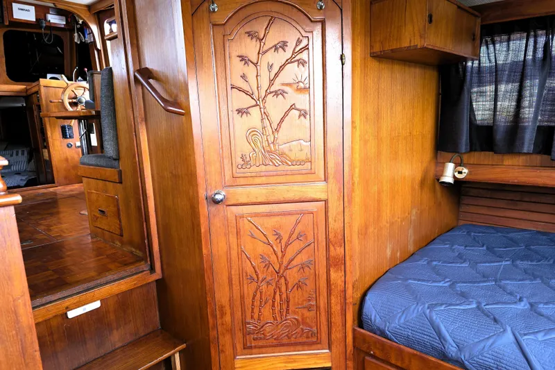 Slide: The Image of Interior of 1978 CHB 34 trawler with carved wooden door and cozy sleeping area. - 18