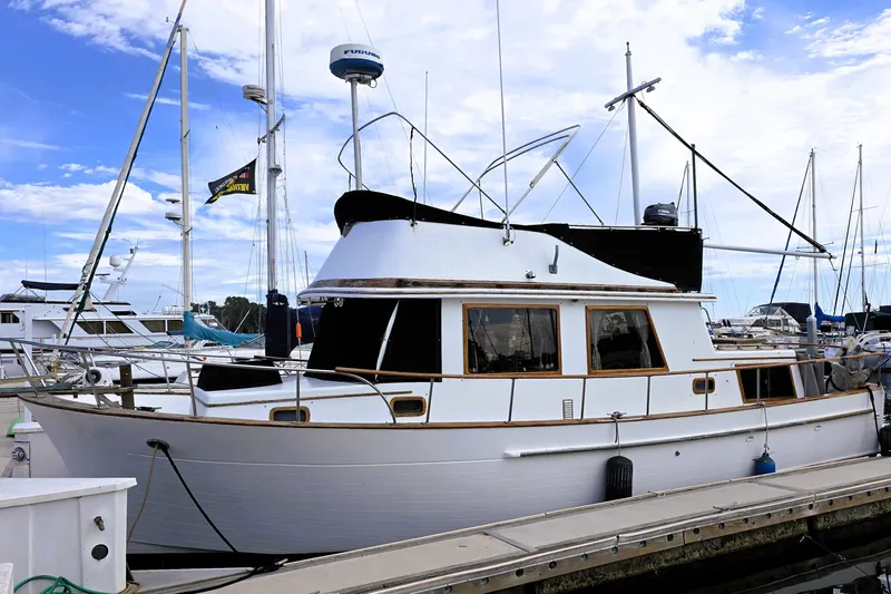 Slide: The Image of 1978 CHB 34 trawler docked at marina under blue sky. - 1