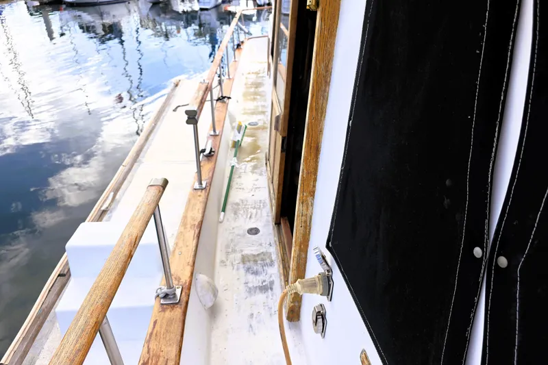 Slide: The Image of 1978 CHB 34 Trawler deck with wooden railings and marina reflections. - 25