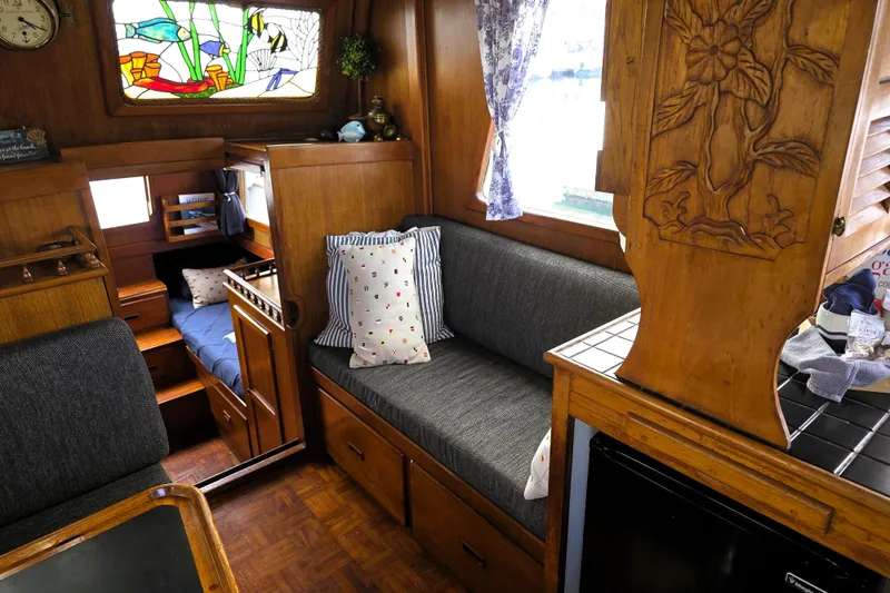 Slide: The Image of Cozy interior of a 1978 CHB 34 trawler with wood accents and stained glass window. - 3