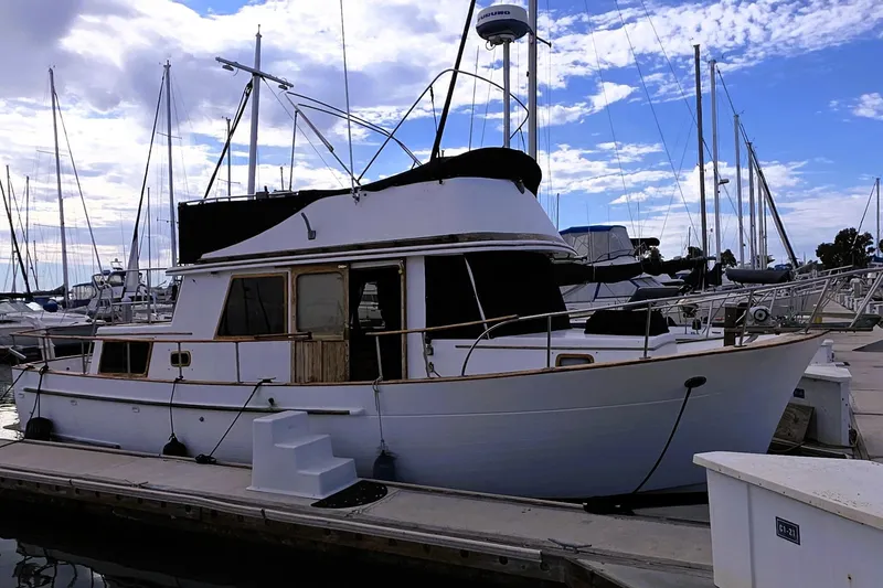 The Image of 1978 CHB 34 Trawler docked at marina under a partly cloudy sky. - 0