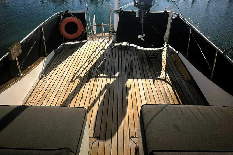 Slide: The Image of Wooden deck of a 1978 CHB 34 trawler with seating and life preserver. - 30