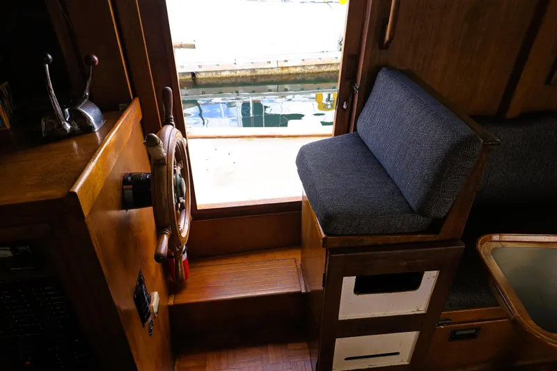 Slide: The Image of Interior of a 1978 CHB 34 trawler with wooden helm and cushioned seating. - 5