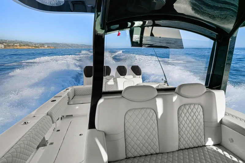 Slide: The Image of The image shows the stern of an HCB 42 Lujo boat on the water. White seats and clear skies are visible. - 24