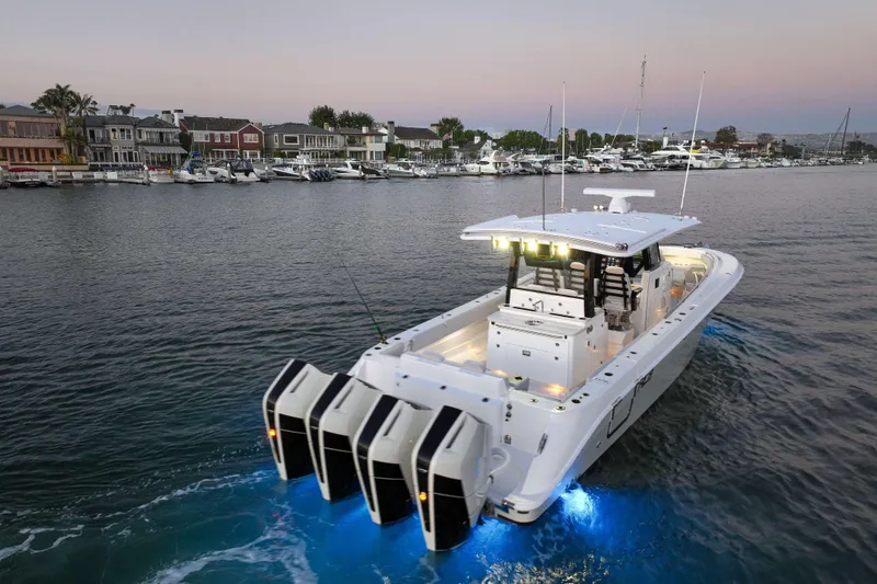 Slide: The Image of A modern motorboat with four outboard engines cruises in a calm harbor at sunset. - 10