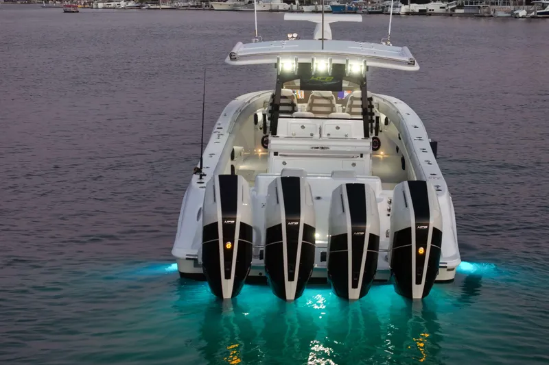 Slide: The Image of A luxurious boat with four outboard engines, illuminated deck, and sleek design on calm waters. - 13