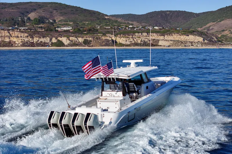 Slide: The Image of 2026 HCB 42 Lujo cruising on the sea with three engines and American flags. - 1