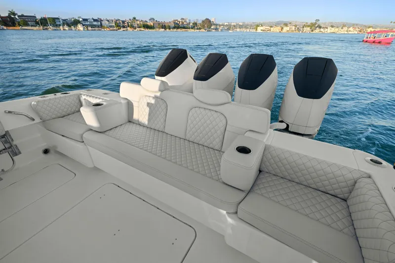 Slide: The Image of The image shows the stern of an HCB 42 Lujo boat with four engines and cushioned seating. - 38