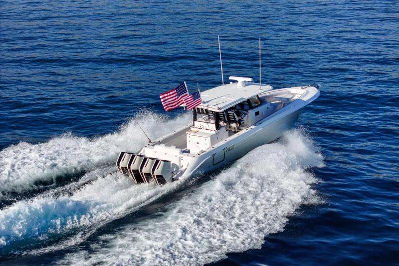 Slide: The Image of A modern boat with four outboard engines speeds across the sea. An American flag waves in the wind. - 3