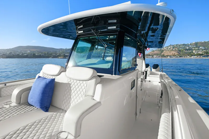 Slide: The Image of The 2026 HCB 42 Lujo features luxurious seating and a modern helm on calm waters. - 19