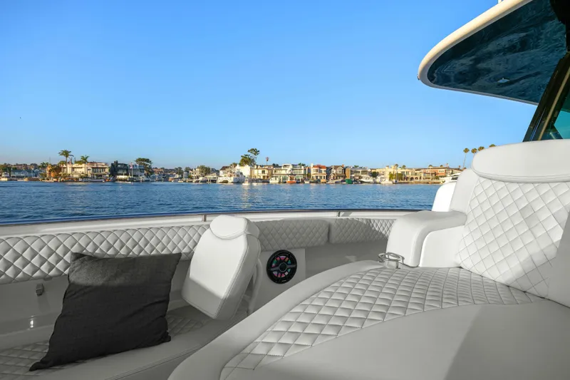 Slide: The Image of Luxurious white seating on a boat with a coastal town visible in the background. - 37