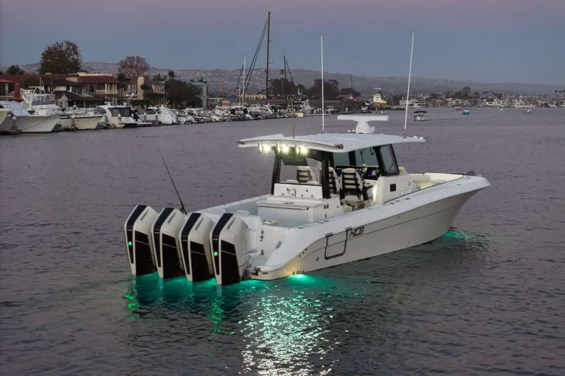 Slide: The Image of A modern 2026 HCB 42 Lujo with four outboard engines and underwater lights on calm water. - 12