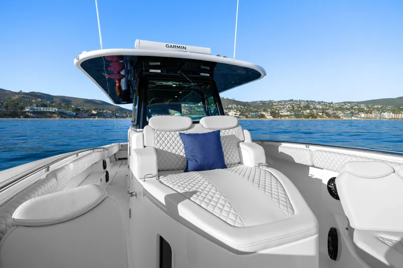 Slide: The Image of The image shows the deck of a 2026 HCB 42 Lujo with luxurious white upholstery and a blue cushion. - 22